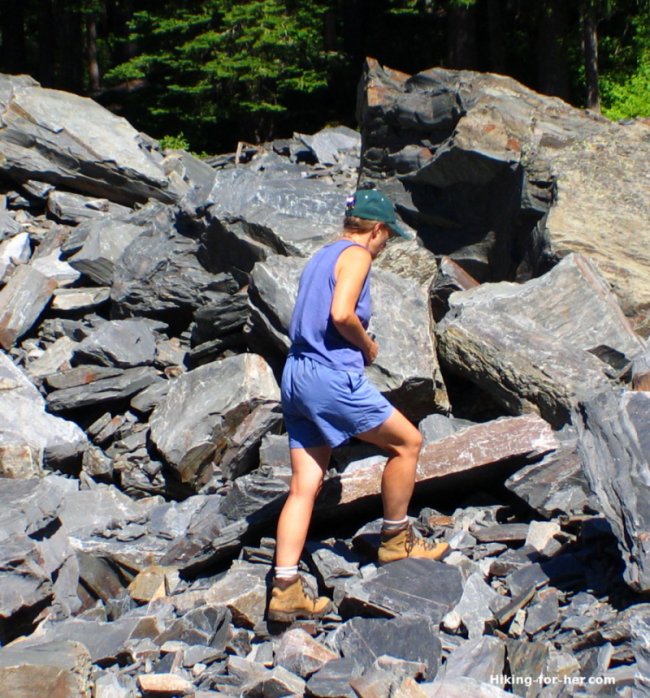 Female hiker wearing heavy leather hiking boots on a rocky slope Female hiker wearing heavy leather hiking boots on a rocky slope