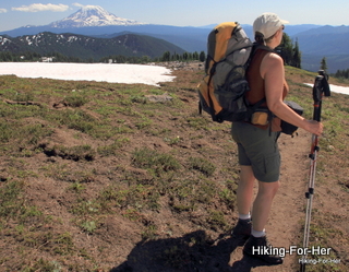 Female backpacker with hiking poles on the Pacific Crest Trail with Mount Adams in background