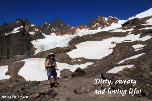 Picture of a female hiker dirty, sweaty, and loving life on a snowfield