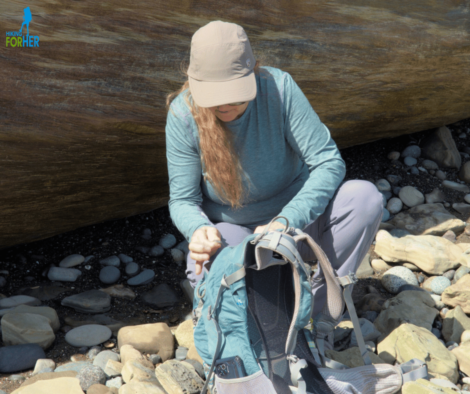 Female hiker crouched down with hands on her  backpack on rocky trail Female hiker crouched down with hands on her  backpack on rocky trail
