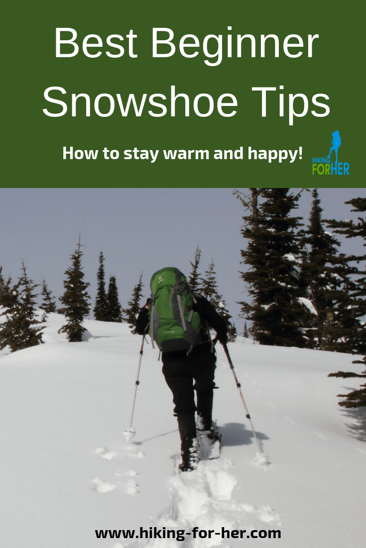 female snowshoer wearing waterproof jacket and pants with green backpack and hiking poles breaking trail uphill