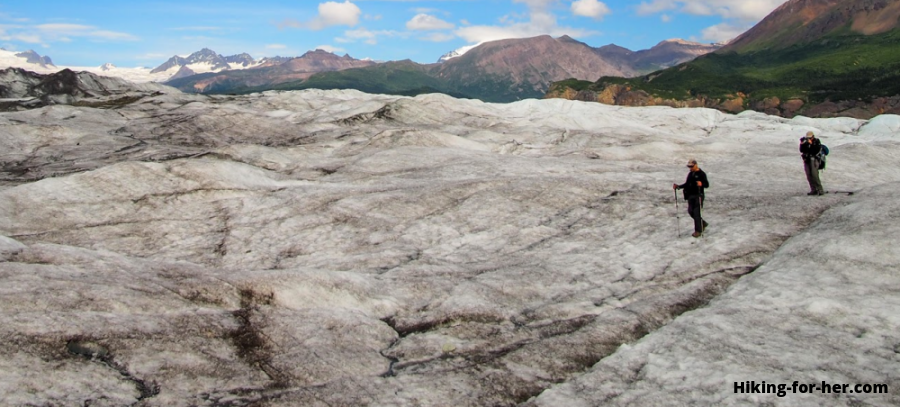 Hikers wandering across the surface of Nizina Glacier, Wrangell St Elias, Alaska