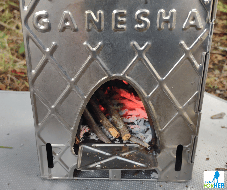 Ganesha ultralight backpacking stove with glowing coals in base of stove