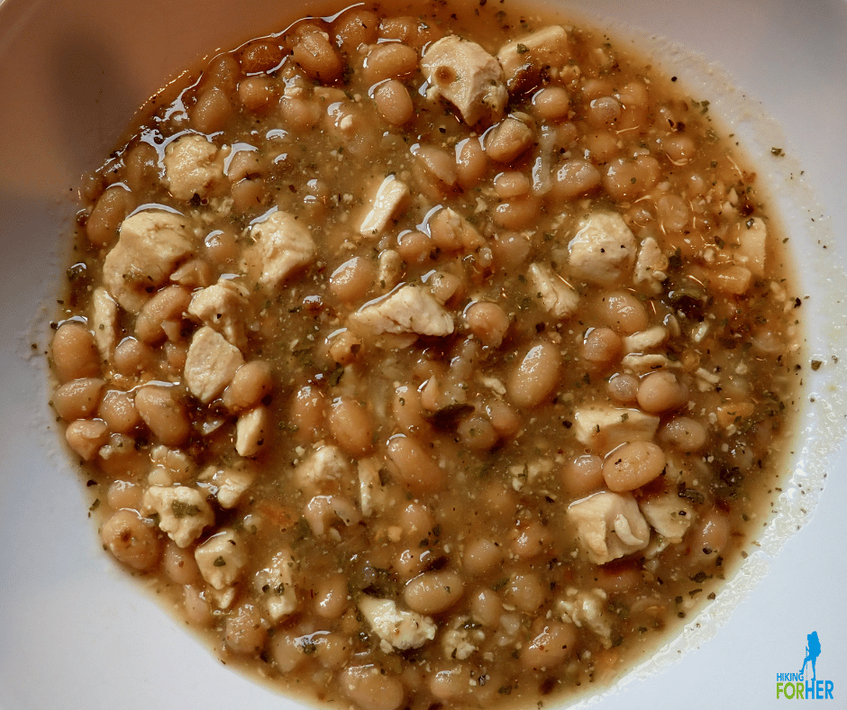 a bowl of backpacking food showing plump beans and chicken