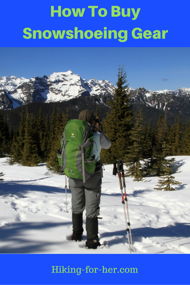female snowshoer wearing green backpack taking a photo of snowy mountains