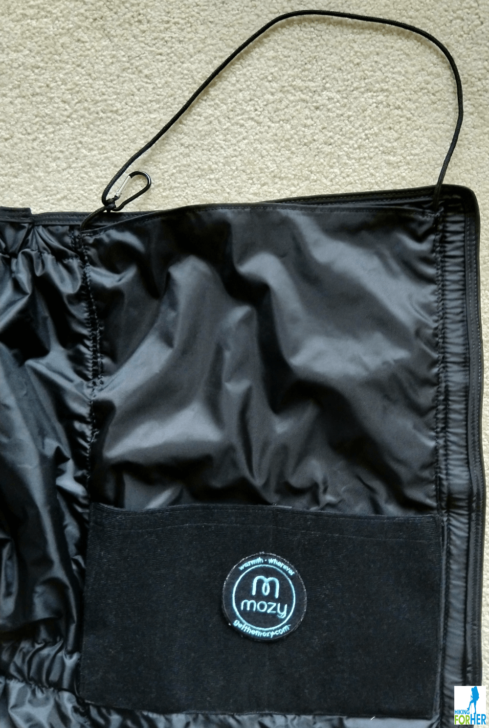 One panel of the Mozy thermal blanket showing carrying loop, carabiner and pockets with Mozy patch