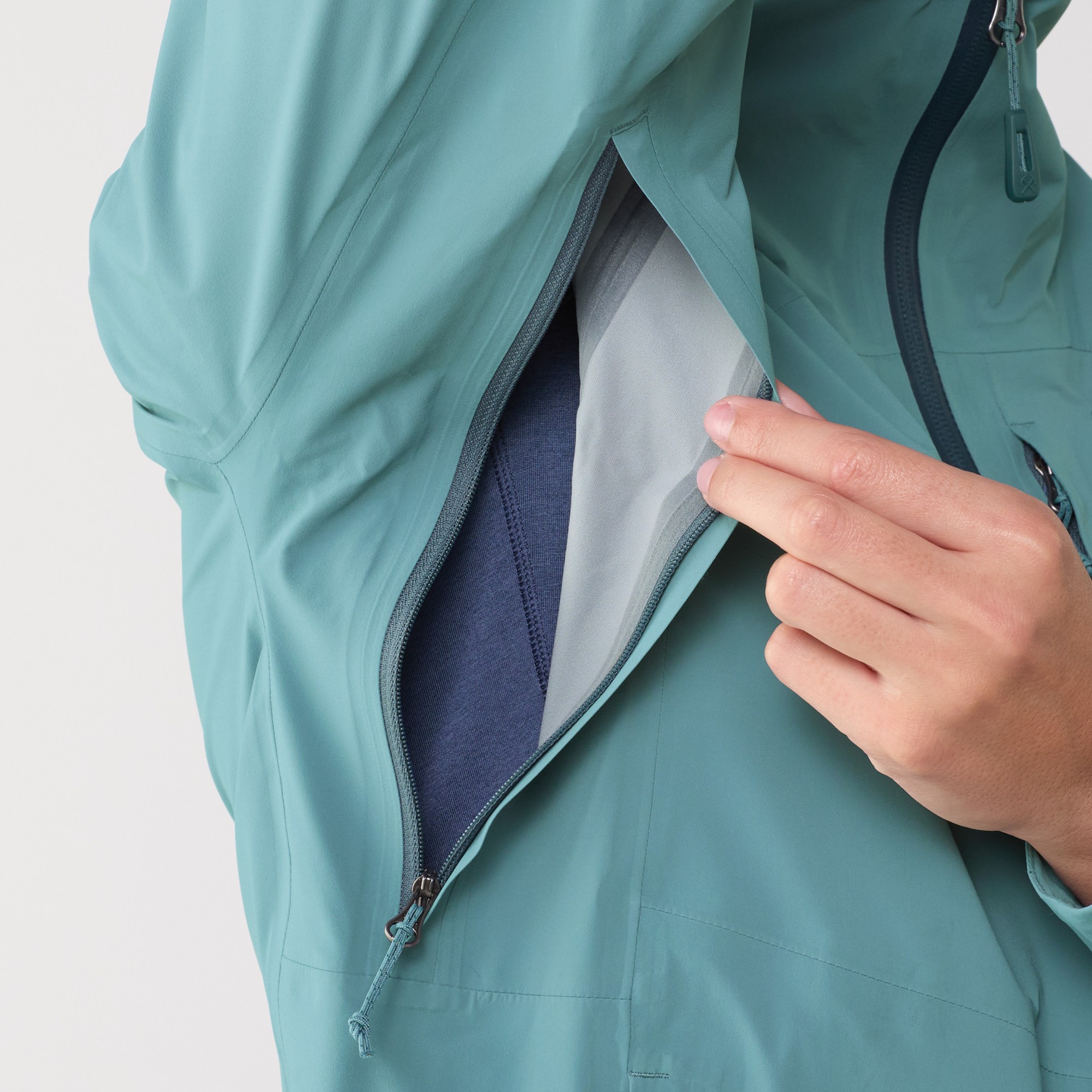 Blue REI Xerocloud rain jacket showing unzipped armpit zip feature