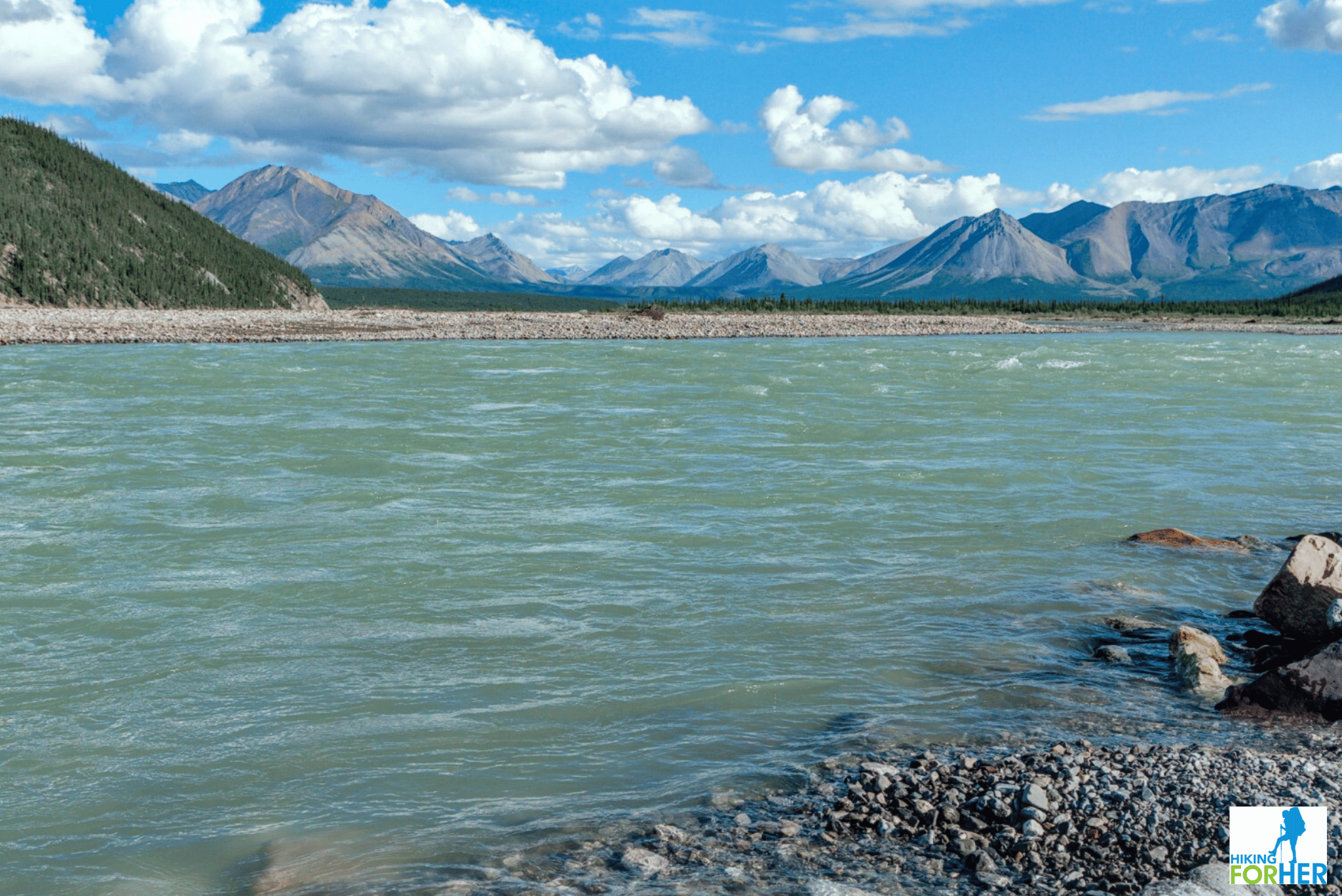 Mountain river bank with peaks in the distance Mountain river bank with peaks in the distance