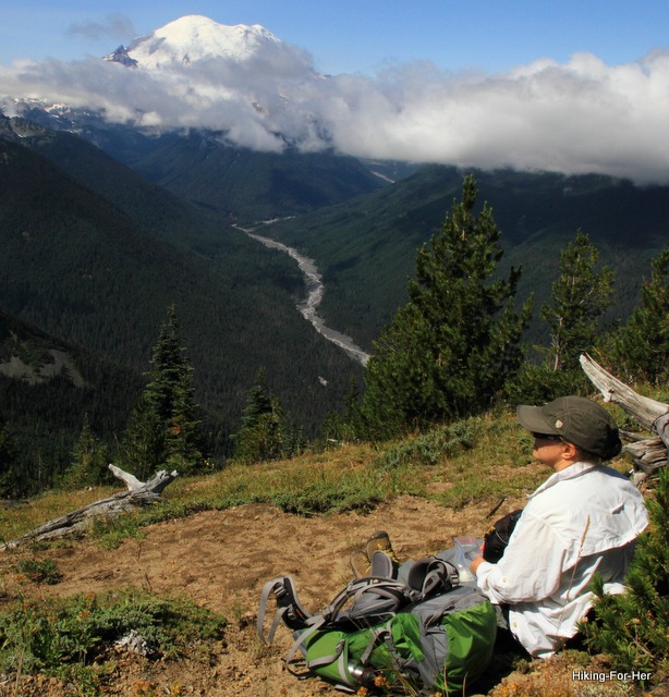 Female hiker gazing across the valley at the White River flowing off Mt. Rainier Female hiker gazing across the valley at the White River flowing off Mt. Rainier